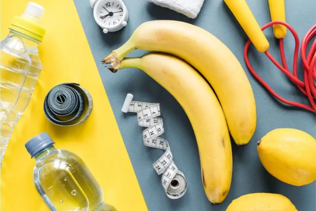 Bananas, água, fita métrica e acessórios de treino, simbolizando nutrição e desempenho desportivo com o teste genético DNA Sport.